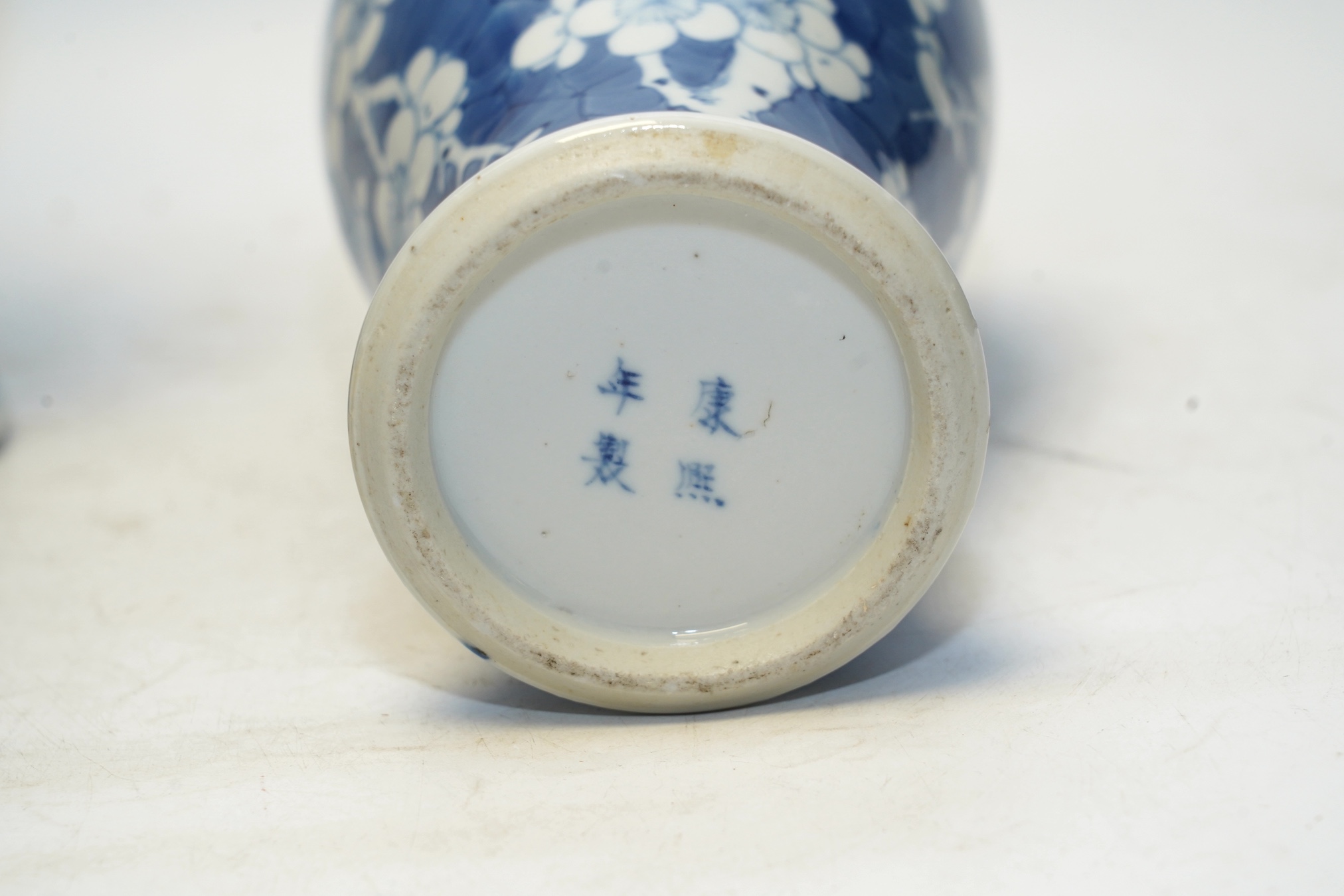 A pair of Chinese blue and white prunus baluster vases and covers, 31cm high. Condition - one vase good, the other pieces poor